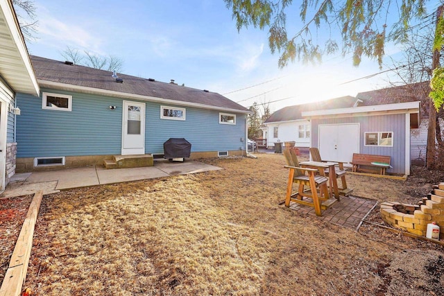 rear view of property featuring an outdoor structure and a patio