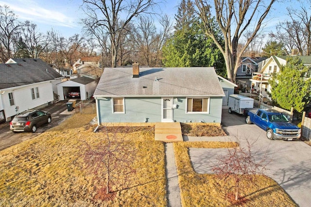 view of front of house featuring a residential view, driveway, and a chimney