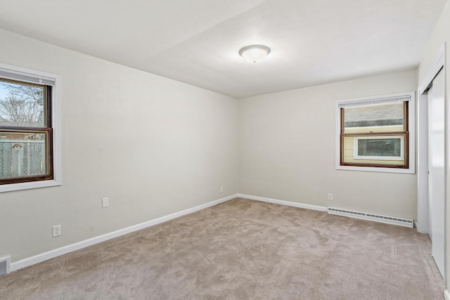 carpeted spare room with visible vents, baseboards, and baseboard heating