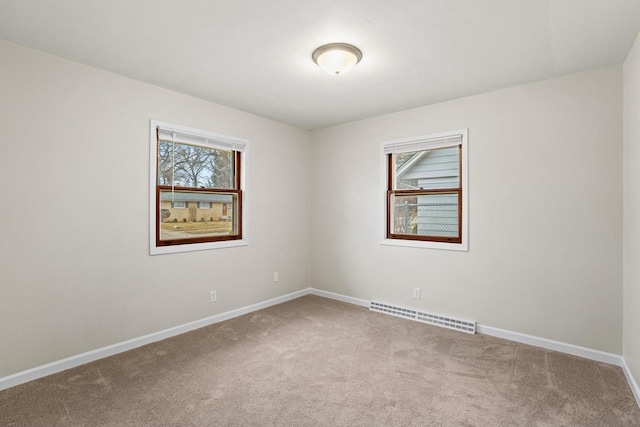 carpeted empty room featuring a wealth of natural light, visible vents, and baseboards