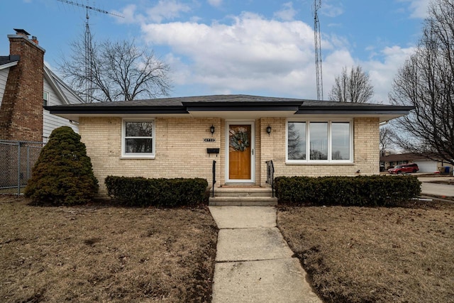 view of front of property featuring fence and brick siding