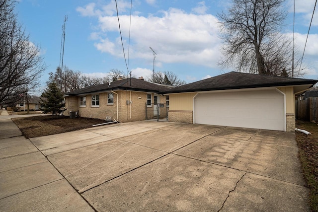 view of front of home featuring an outbuilding, a garage, brick siding, fence, and driveway