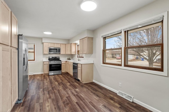 kitchen with dark wood-style floors, visible vents, light brown cabinetry, appliances with stainless steel finishes, and a sink