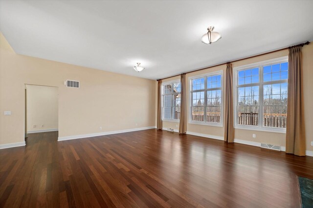 N37W22910 Wyndemere Dr, Pewaukee, WI 53072 - empty room featuring dark wood finished floors, visible vents, and a healthy amount of sunlight