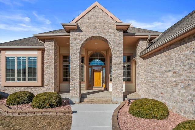 doorway to property with roof with shingles