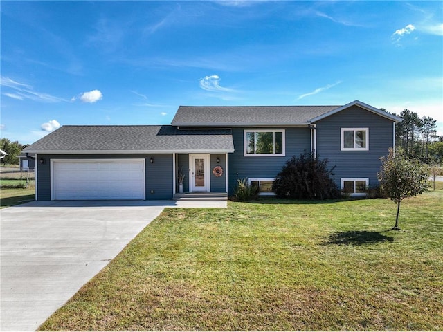 tri-level home with a garage, concrete driveway, roof with shingles, and a front yard