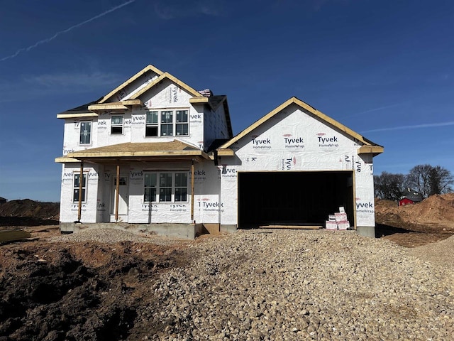 property under construction with covered porch and a garage