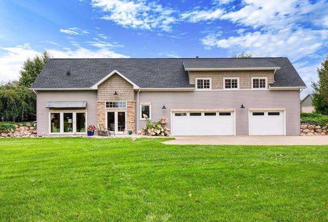 back of property featuring a garage, a yard, french doors, and roof with shingles