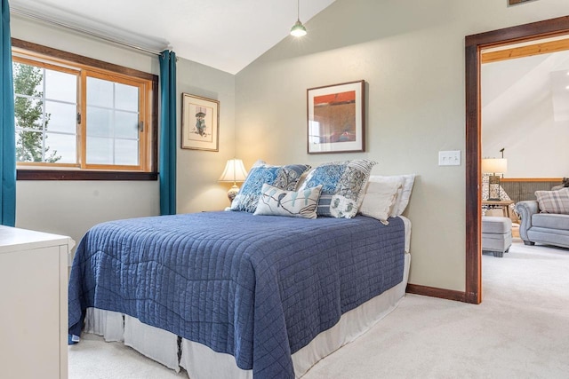 carpeted bedroom featuring lofted ceiling and baseboards