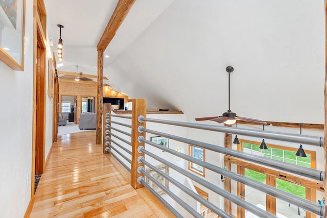 hall featuring lofted ceiling with beams, hardwood / wood-style flooring, and an upstairs landing