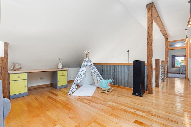 game room with light wood-type flooring, vaulted ceiling with beams, and built in study area