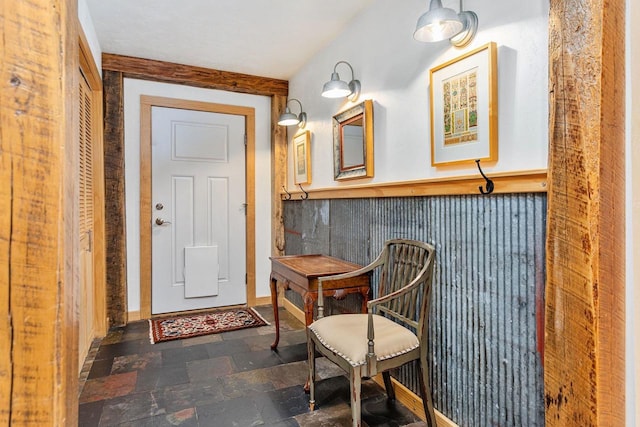 entryway with a wainscoted wall and stone tile floors