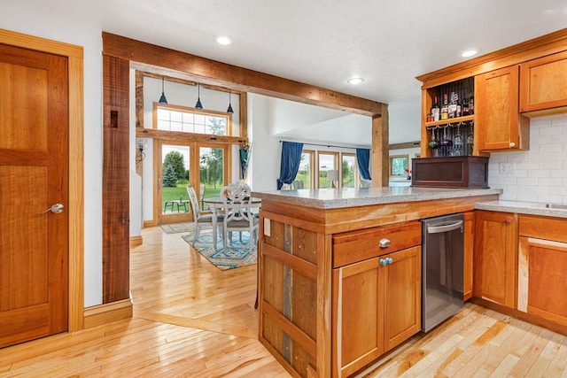 kitchen featuring light wood-style flooring, brown cabinets, a peninsula, open shelves, and backsplash