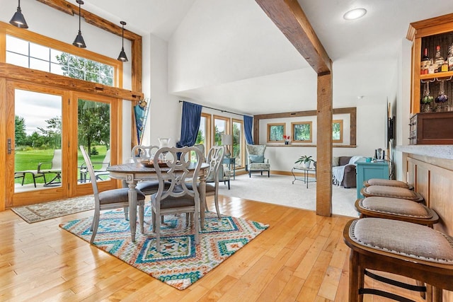 dining room featuring high vaulted ceiling, beamed ceiling, and wood-type flooring