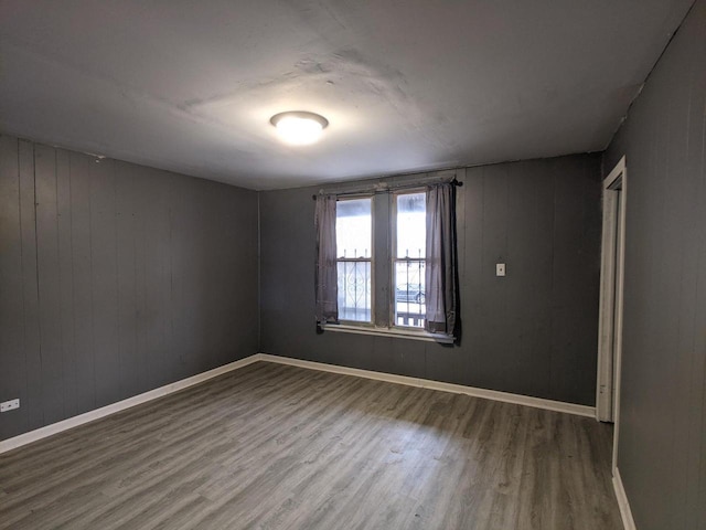 empty room with baseboards and wood finished floors