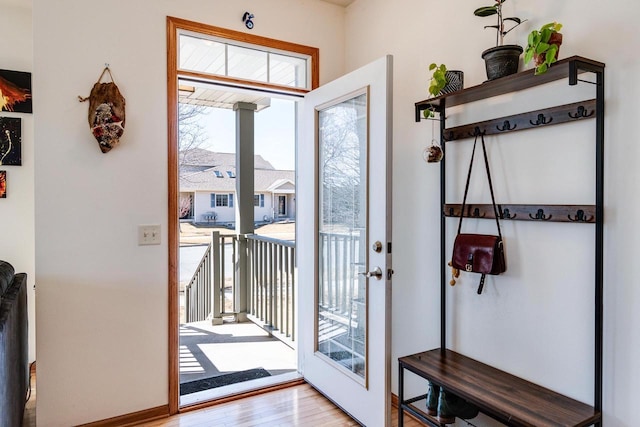 doorway featuring baseboards and wood finished floors