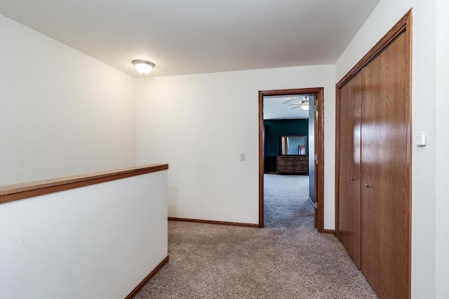 corridor with light colored carpet and baseboards