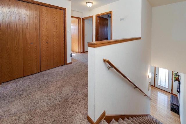 hallway featuring an upstairs landing and carpet floors