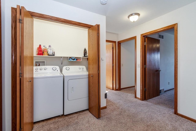 laundry area with washing machine and clothes dryer, laundry area, light carpet, and visible vents