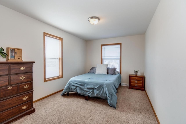 bedroom with baseboards and light carpet