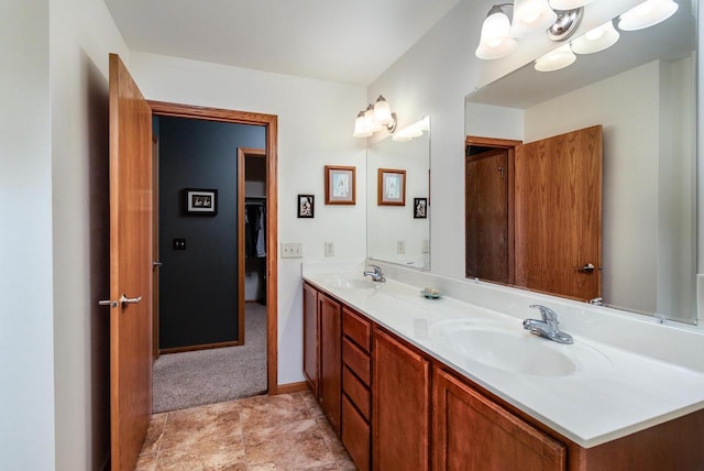 bathroom with double vanity, baseboards, and a sink