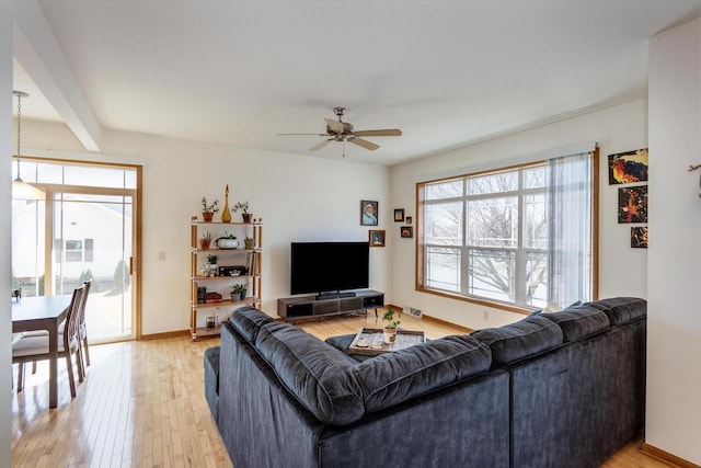 living room featuring visible vents, baseboards, light wood finished floors, and ceiling fan