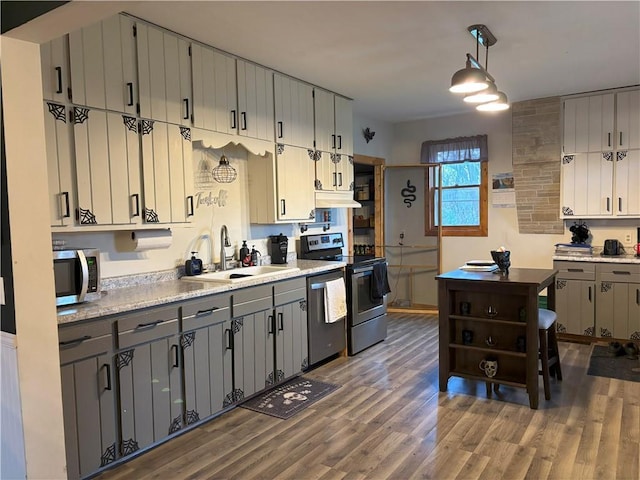 kitchen with wood finished floors, a sink, light countertops, appliances with stainless steel finishes, and gray cabinets