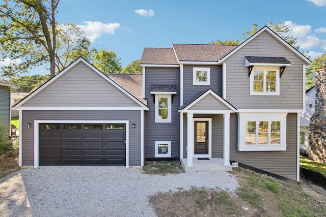 view of front facade featuring a garage, a shingled roof, and driveway