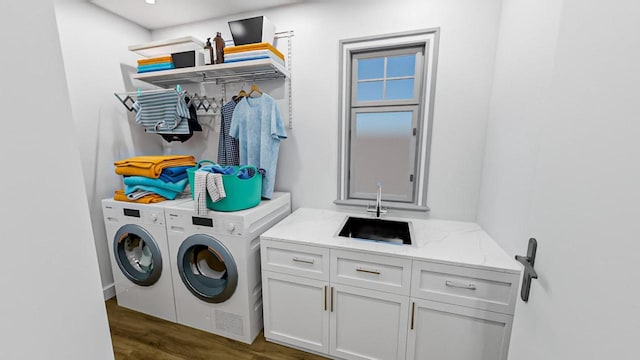 clothes washing area with cabinet space, dark wood-style floors, separate washer and dryer, and a sink