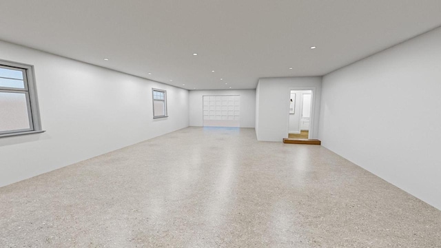 unfurnished room featuring recessed lighting and speckled floor