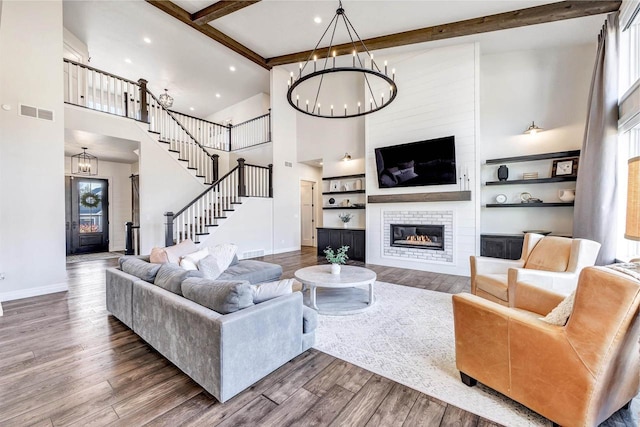 living area featuring stairs, a fireplace, and wood finished floors