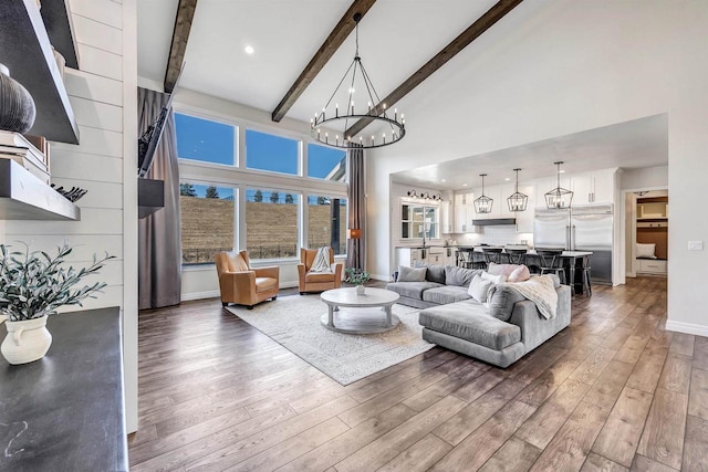 living room featuring baseboards, wood finished floors, beamed ceiling, high vaulted ceiling, and a notable chandelier