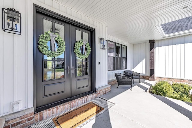 property entrance with covered porch, french doors, and board and batten siding