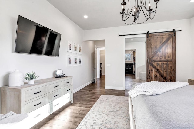 bedroom featuring recessed lighting, wood finished floors, baseboards, and a barn door