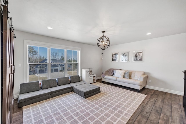 unfurnished living room featuring recessed lighting, an inviting chandelier, baseboards, and hardwood / wood-style flooring