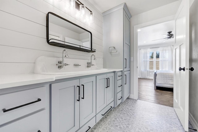 bathroom featuring connected bathroom, vanity, baseboards, a ceiling fan, and tile patterned floors