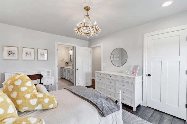 bedroom featuring an inviting chandelier, connected bathroom, and dark wood-style flooring