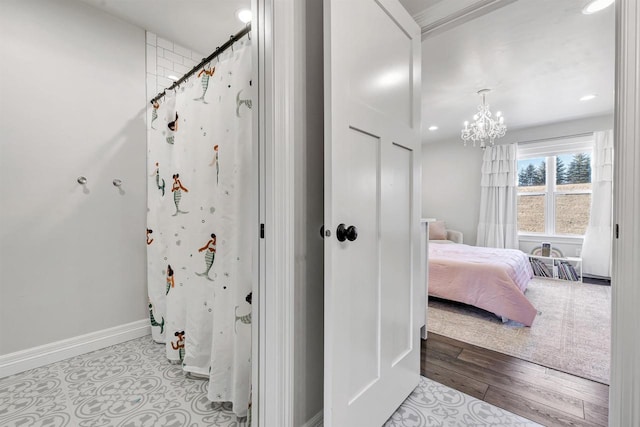 interior space with baseboards, wood finished floors, curtained shower, a notable chandelier, and recessed lighting