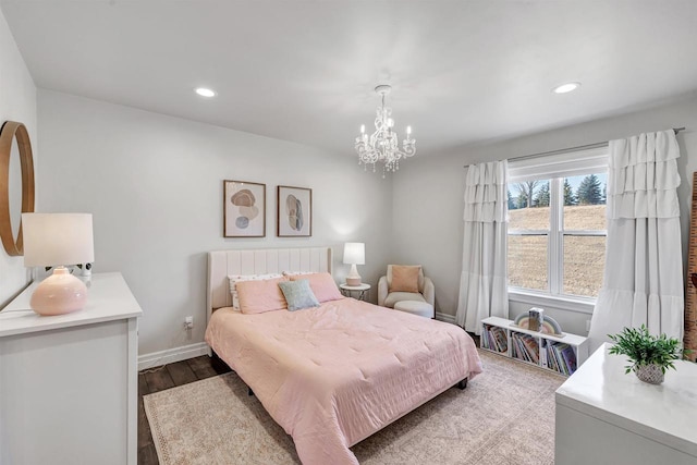 bedroom with recessed lighting, an inviting chandelier, baseboards, and wood finished floors