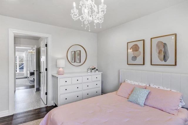 bedroom featuring a chandelier and dark wood finished floors