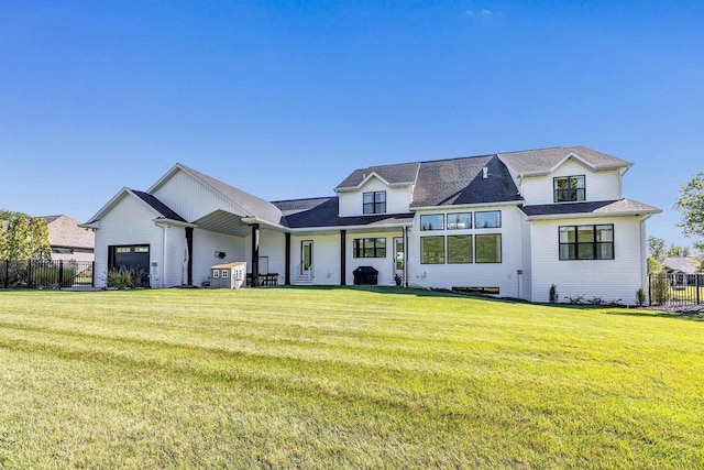 modern farmhouse featuring a garage, a front yard, and fence