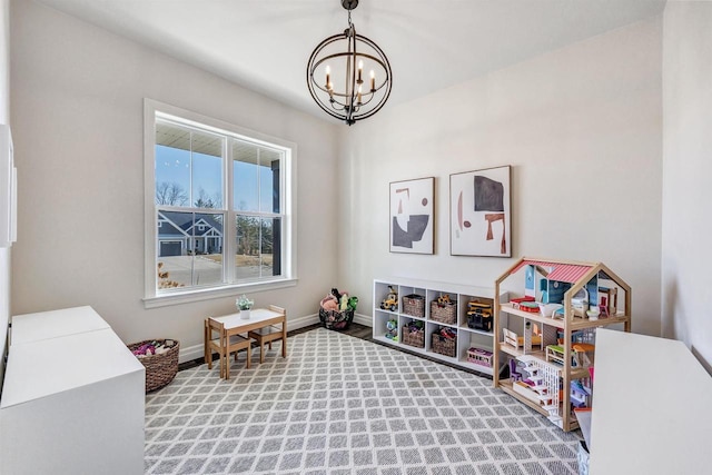 rec room featuring baseboards and a notable chandelier