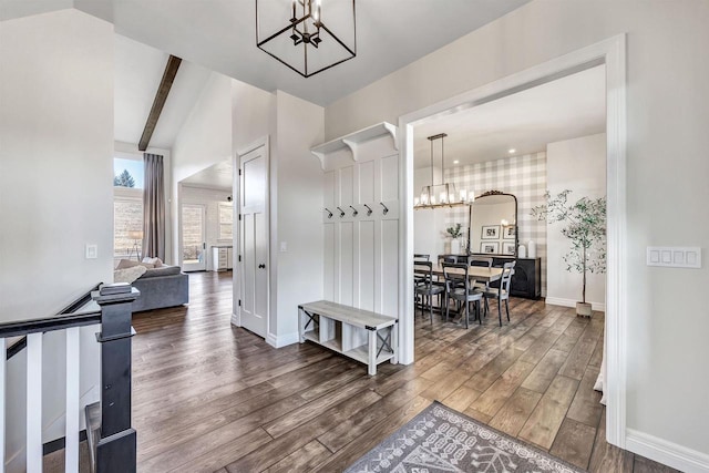 hallway featuring a chandelier, lofted ceiling with beams, wood finished floors, and baseboards