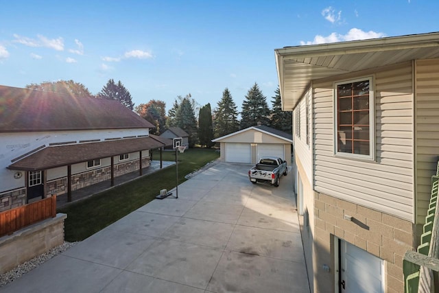 view of side of property with a yard, an outdoor structure, and a detached garage