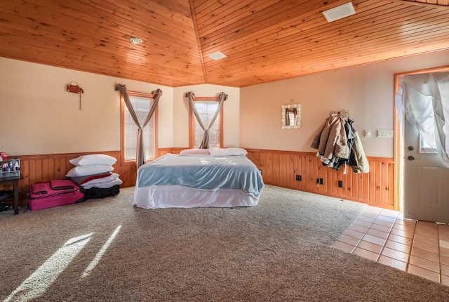 carpeted bedroom featuring a wainscoted wall, tile patterned flooring, wood ceiling, and lofted ceiling