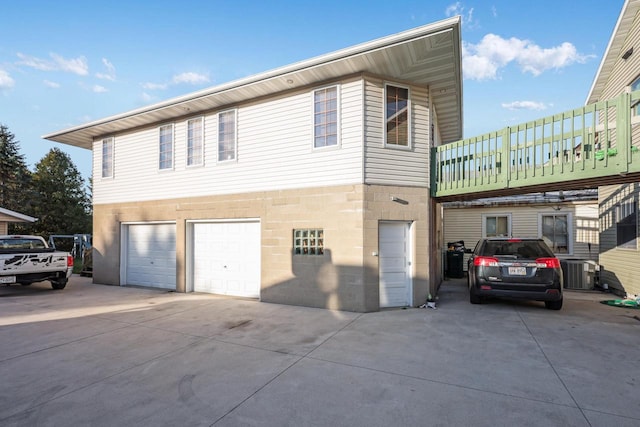 view of front facade featuring a garage and central air condition unit