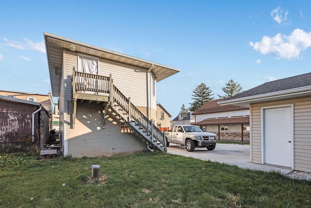 back of property with a yard and stairway