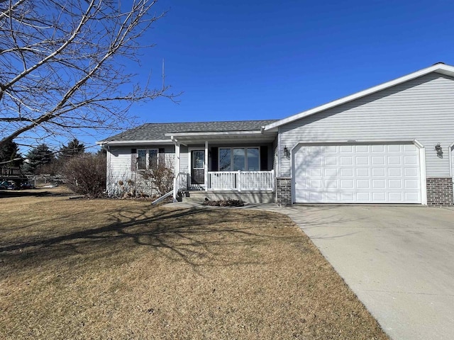 view of front facade featuring a porch, an attached garage, brick siding, concrete driveway, and a front lawn