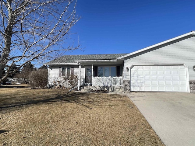 view of front of home with concrete driveway, an attached garage, covered porch, a front lawn, and brick siding