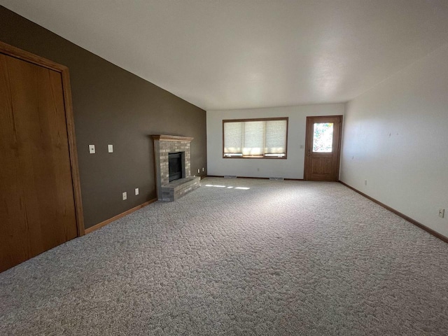 unfurnished living room featuring carpet floors, a brick fireplace, baseboards, and lofted ceiling